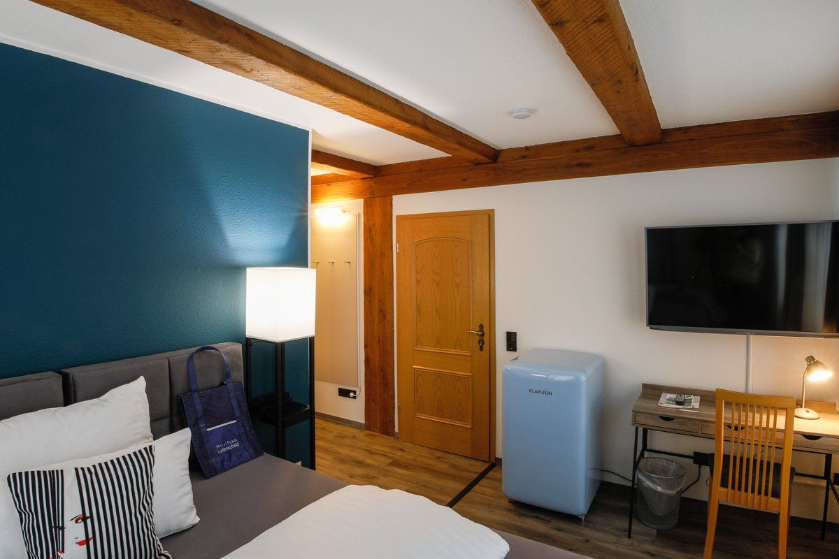 Ein Hotelzimmer mit Bett, Schreibtisch und Fernseher