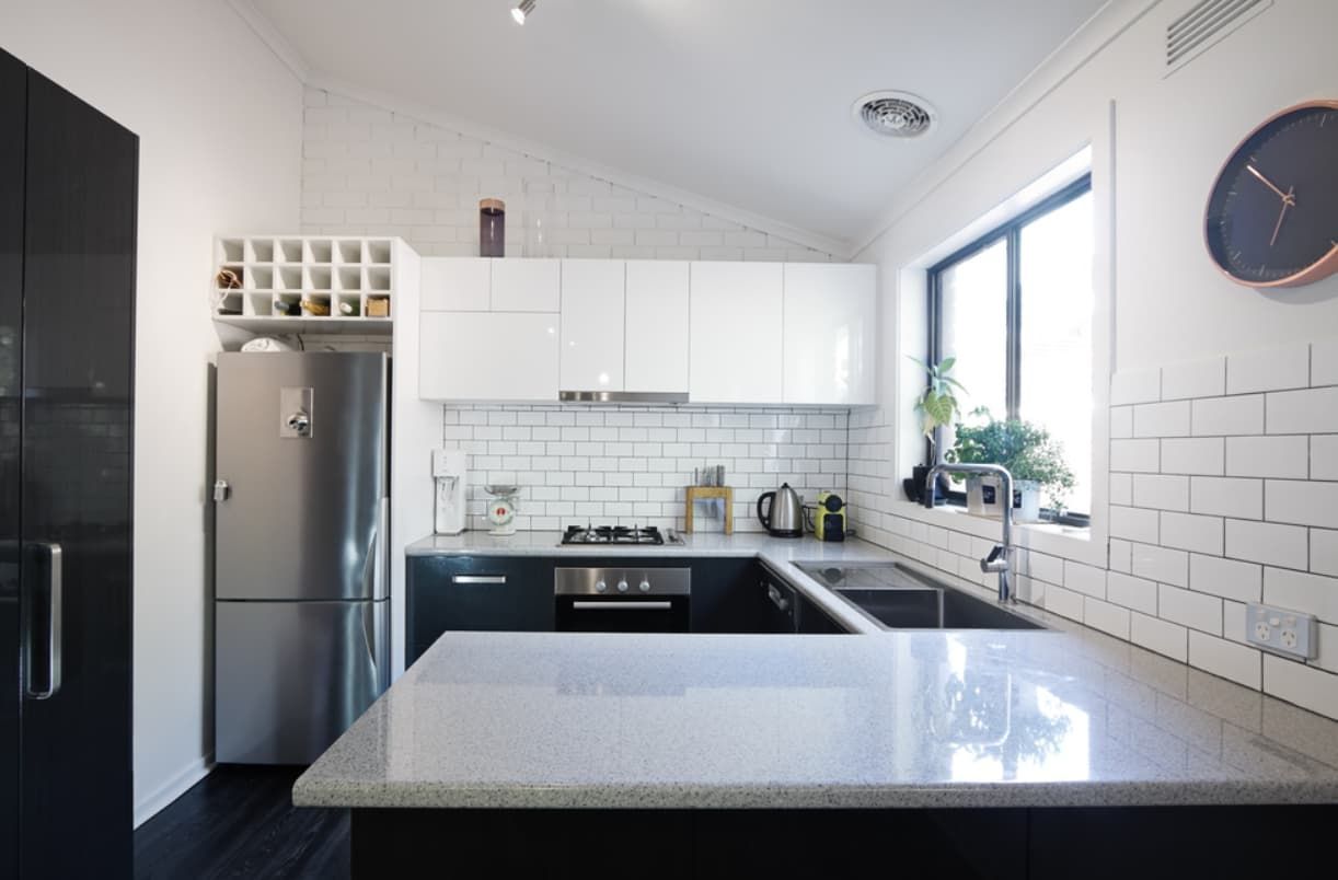 A Kitchen With Black Cabinets And White Counter Tops — Content Stone In Trenayr, NSW