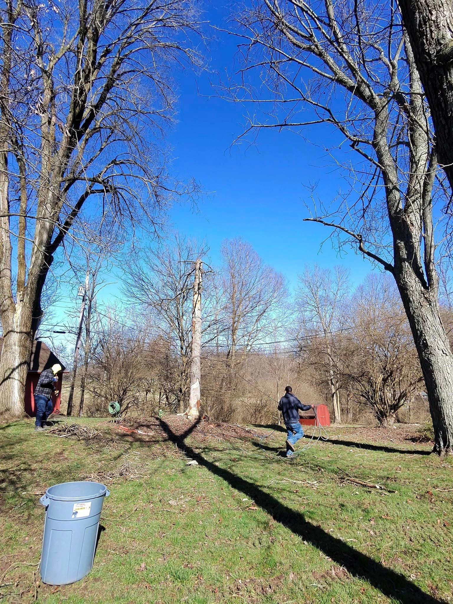 A group of people are standing in a field with trees in the background.