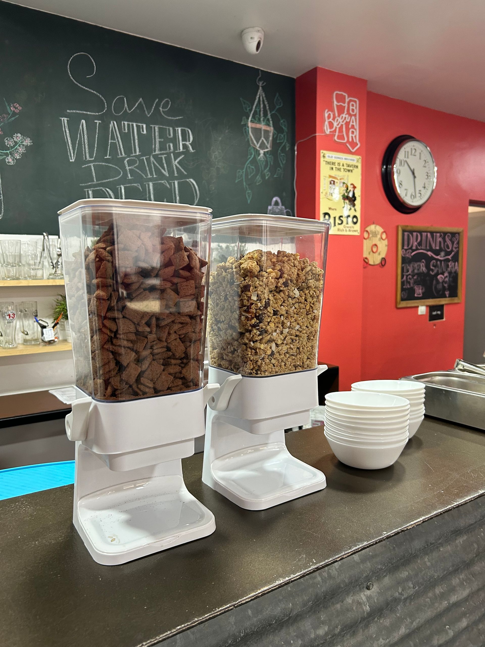 Hay tres dispensadores de cereales sobre un mostrador en un restaurante.