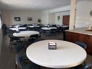 There are many tables and chairs in the room.