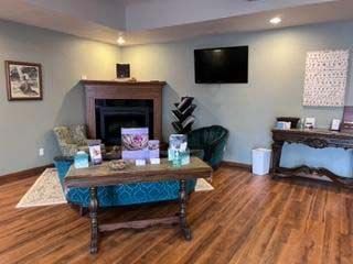 A living room with a fireplace , couch , table and chairs.