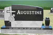 A black and white gravestone for augustine in a cemetery.