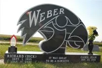 A gravestone for richard weber in a cemetery with flowers and a candle.