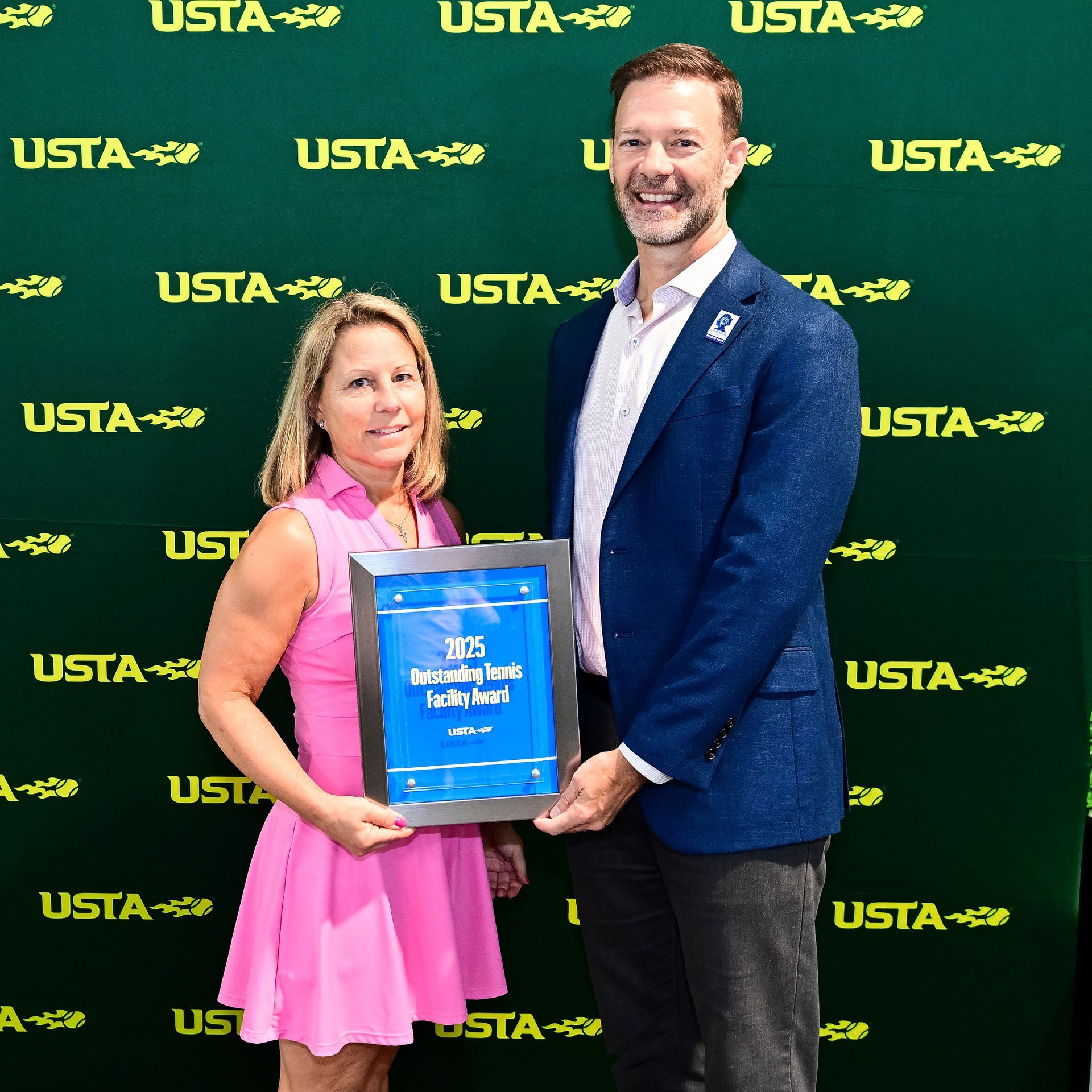 Tracy French holding the 2025 Outstanding Tennis Facility Award from the USTA at the US Open