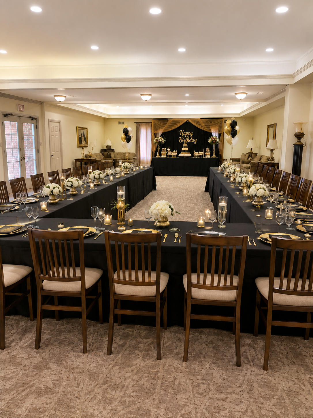 Elegant banquet hall with a long black-draped table and wooden chairs, set for a formal event