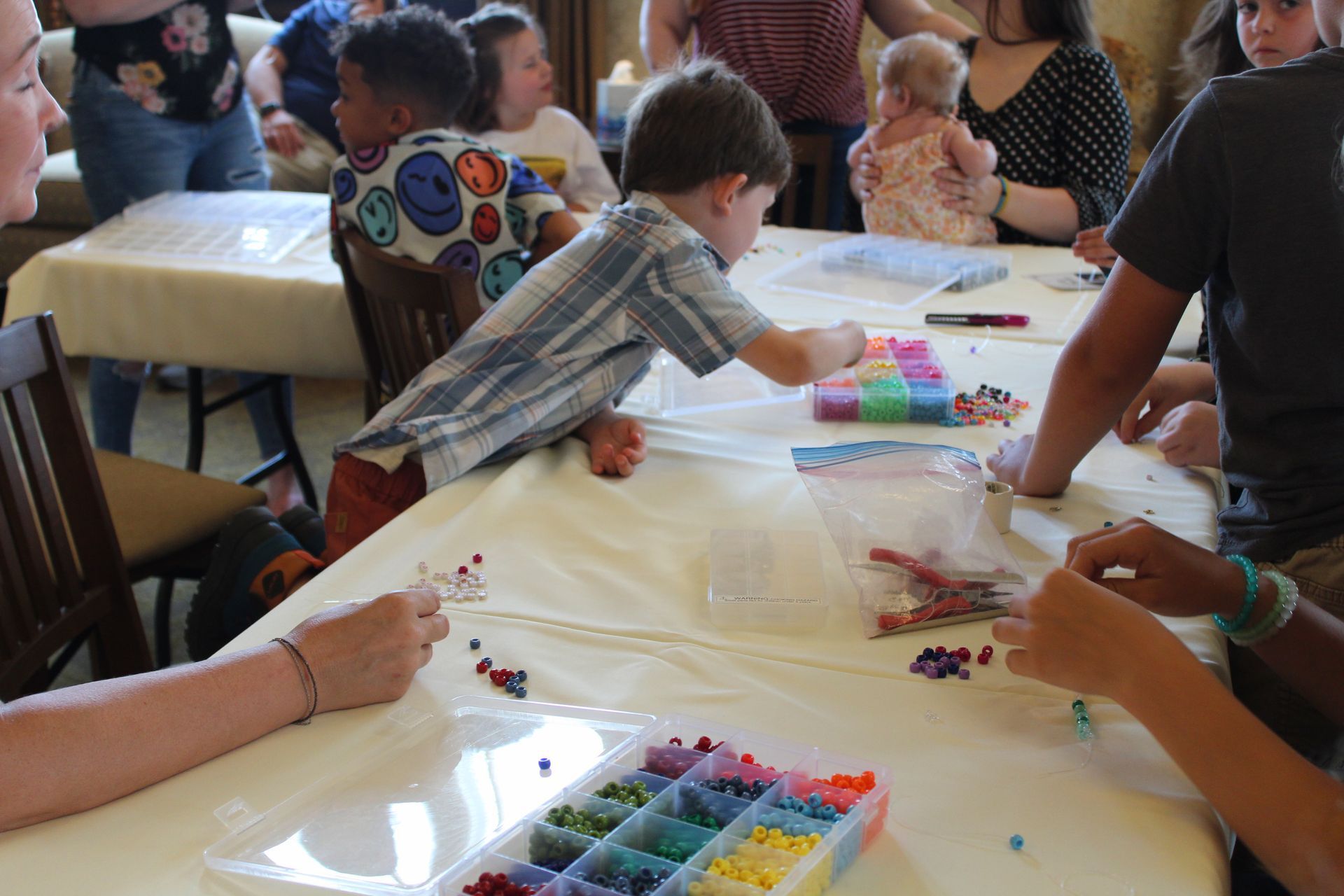 Children doing a colorful craft project at a table in a classroom setting