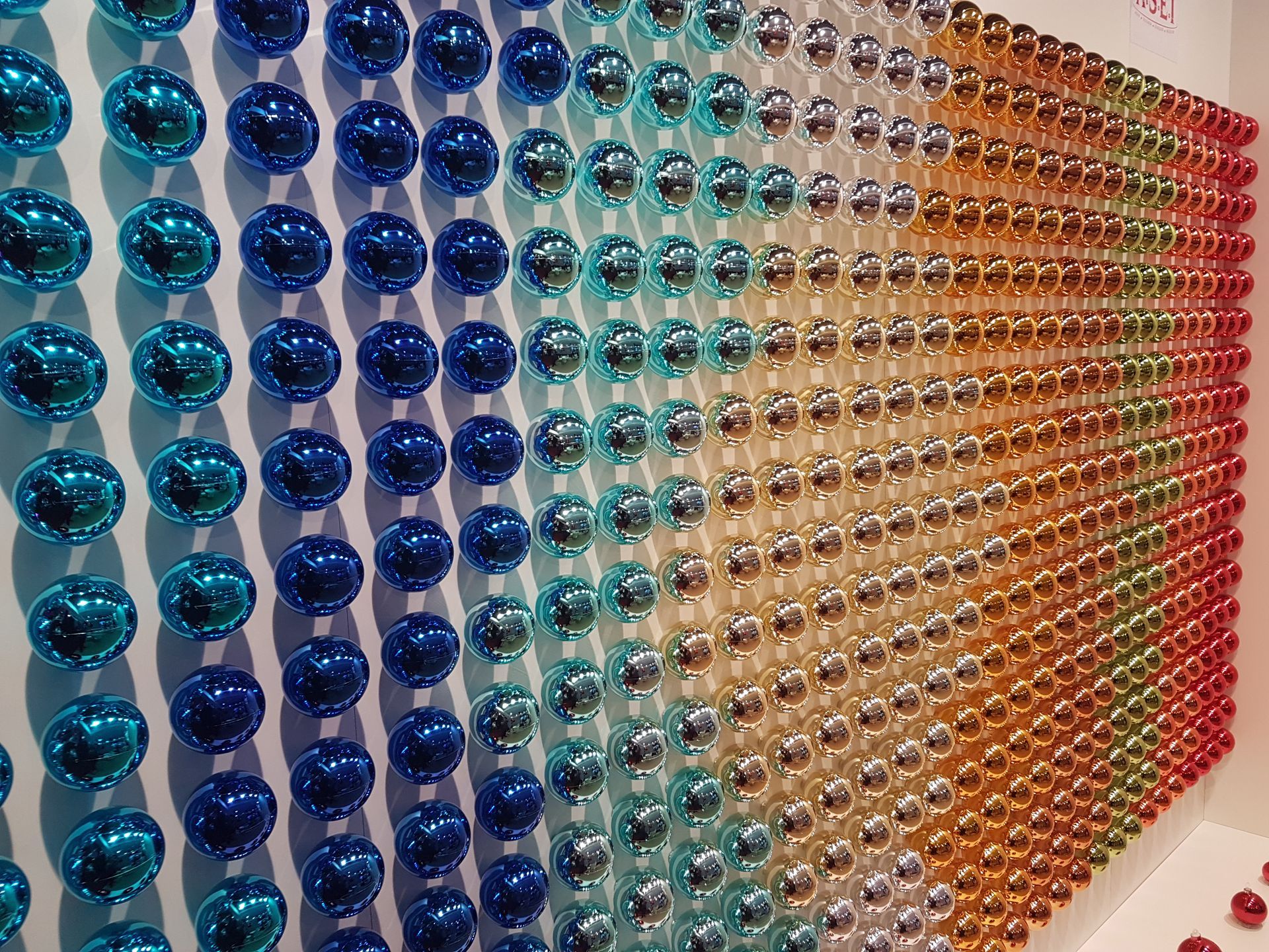 A wall filled with lots of different coloured baubles.