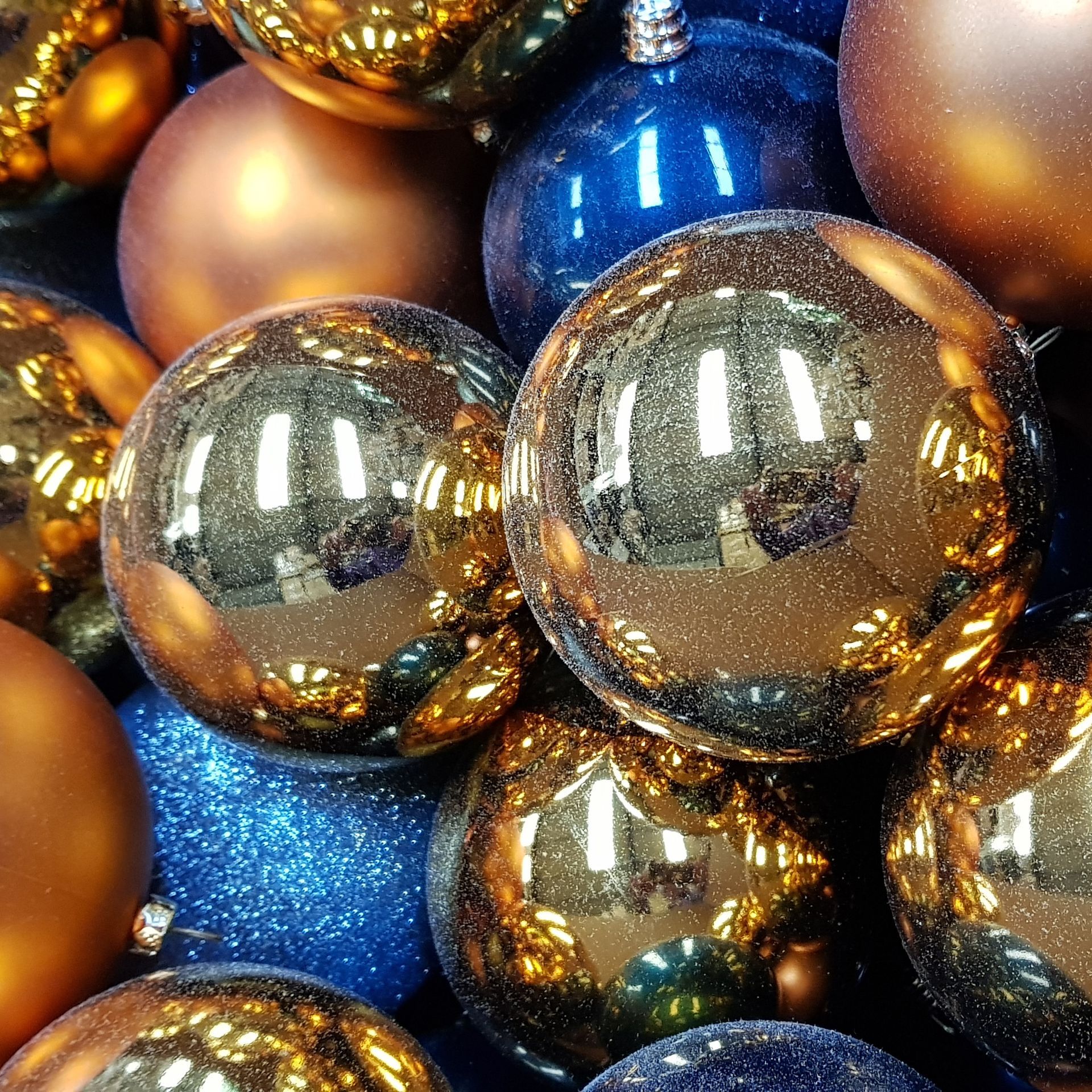 A pile of blue and gold christmas ornaments.