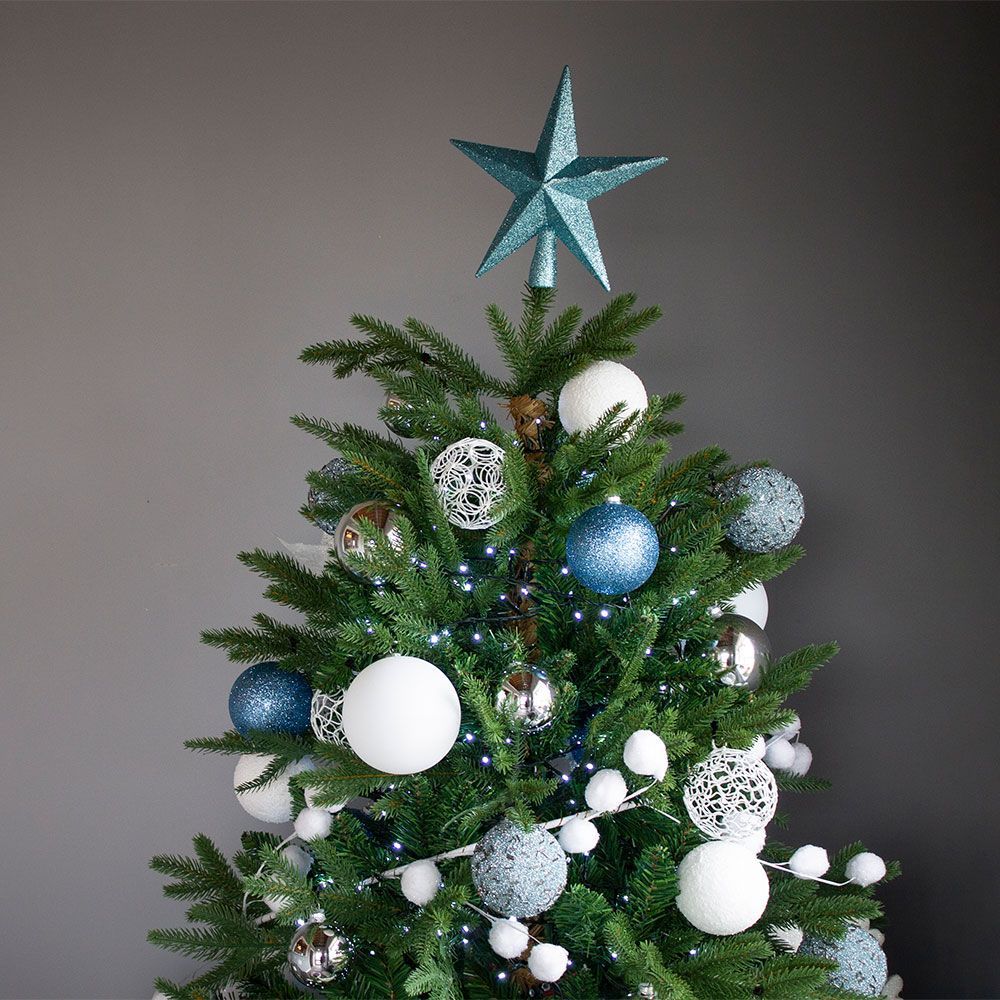 A christmas tree with blue and white ornaments and a star on top