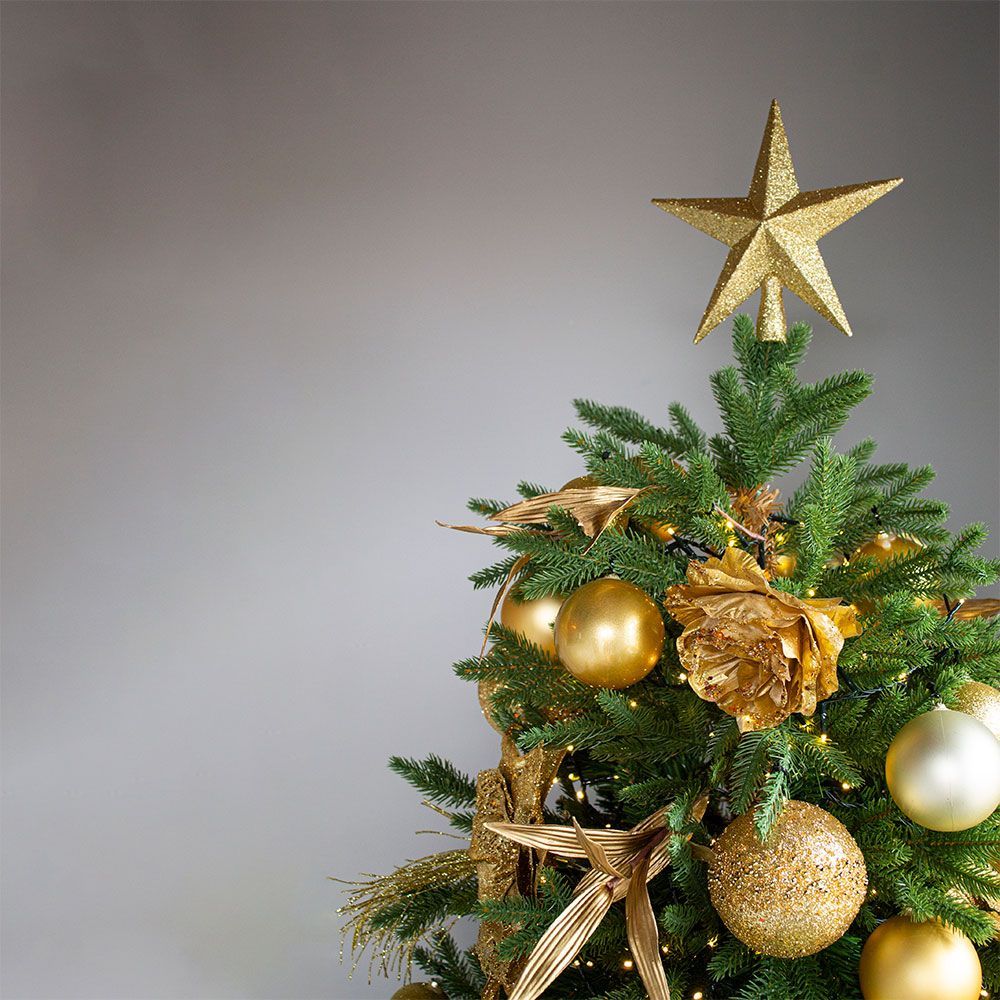 A christmas tree with gold ornaments and a gold star on top