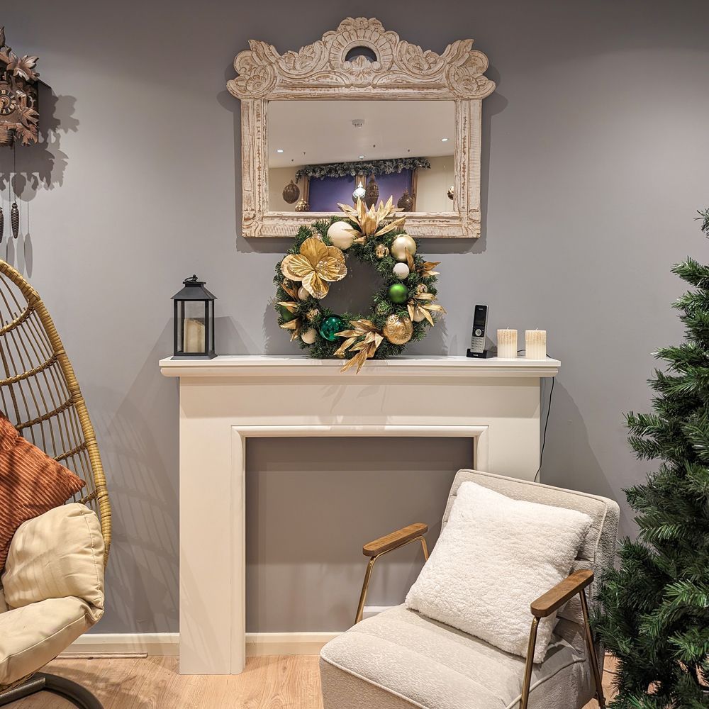 A living room with a chair and a christmas wreath.