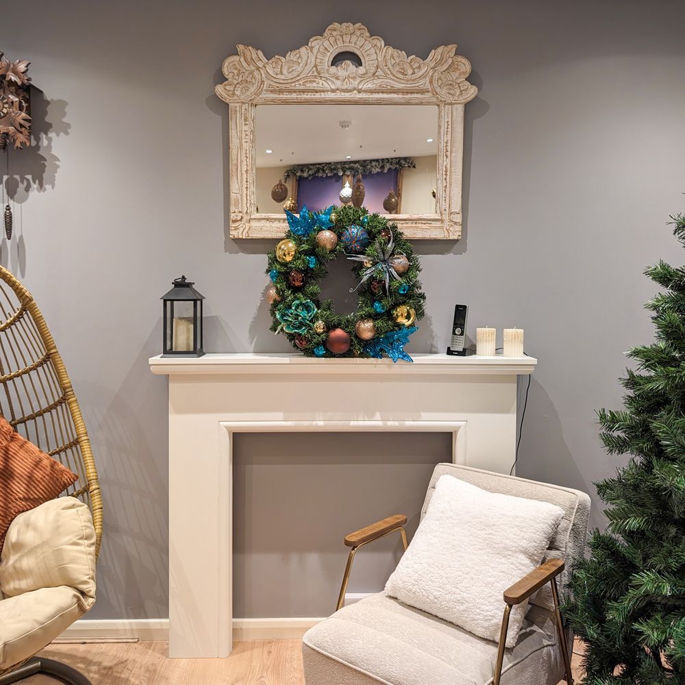 A living room with a chair and a christmas wreath.
