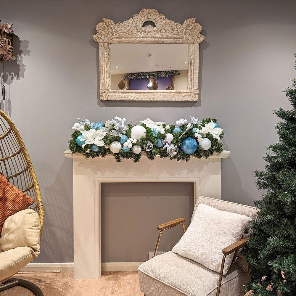 A living room with a fireplace and a christmas wreath.