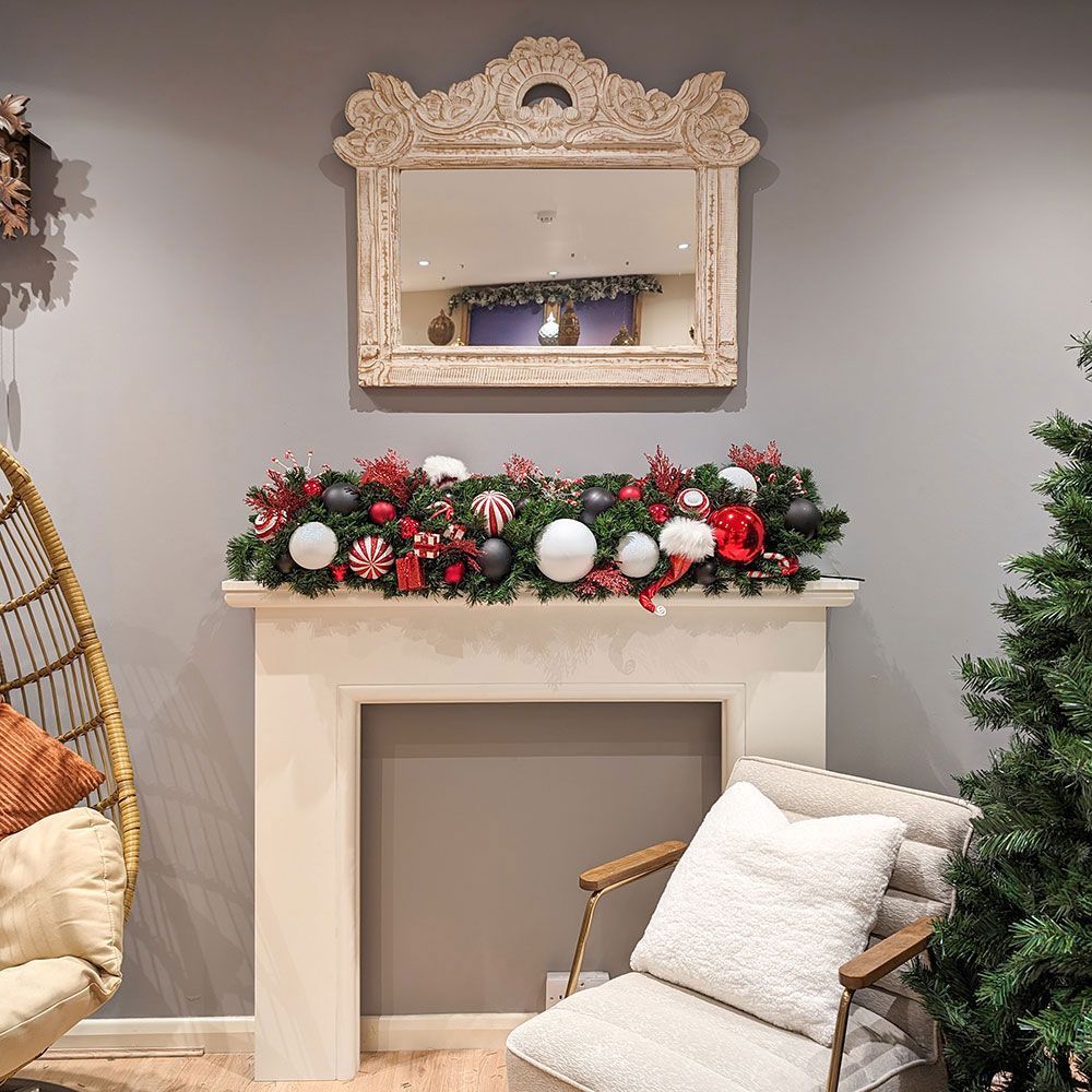 A living room with a chair and a fireplace decorated for christmas.
