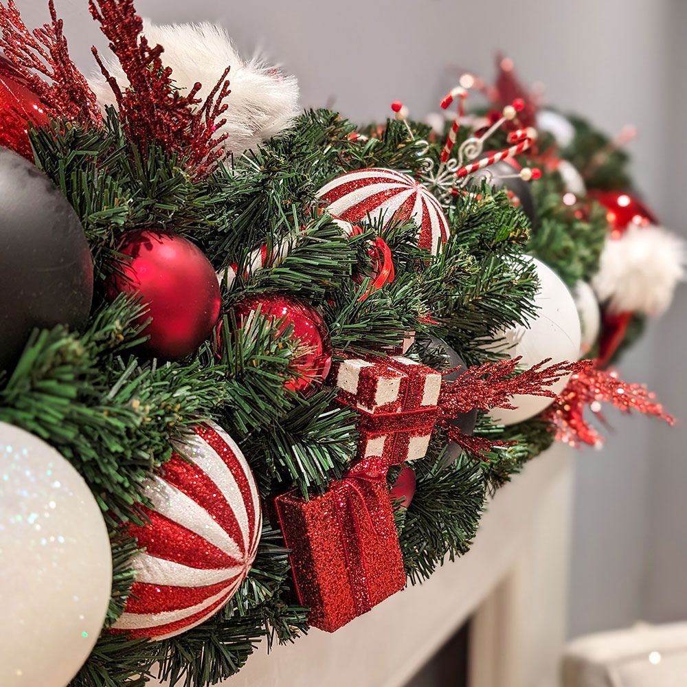 A christmas garland is sitting on top of a fireplace mantle.