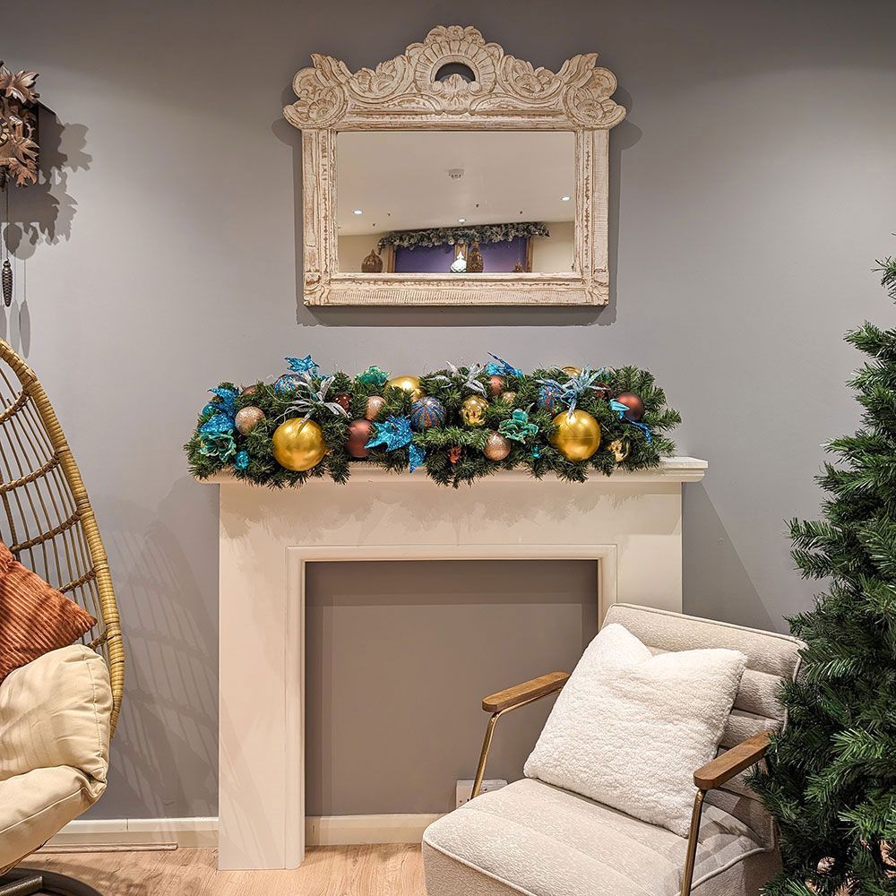 A living room with a mantle decorated for christmas.