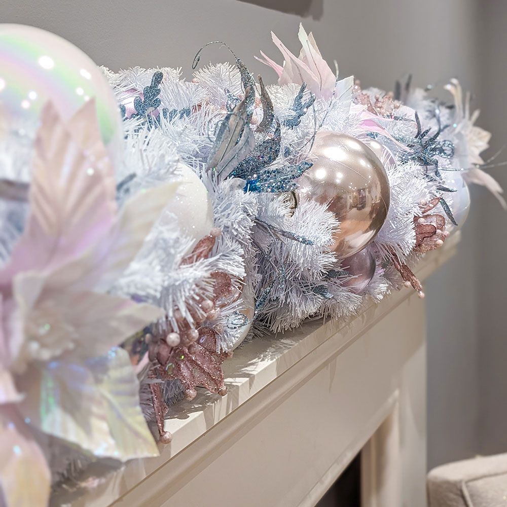 A christmas garland is sitting on top of a fireplace mantle.