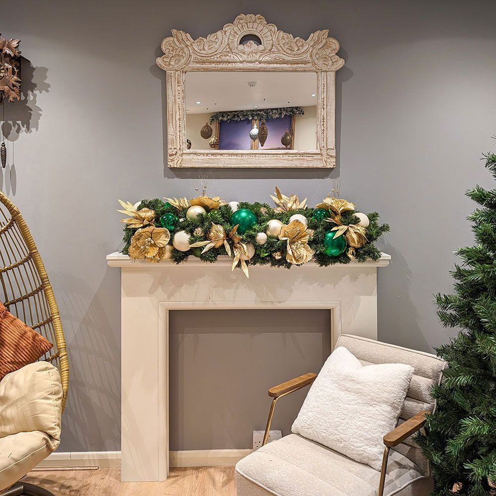 A living room with a chair and a fireplace decorated for christmas.