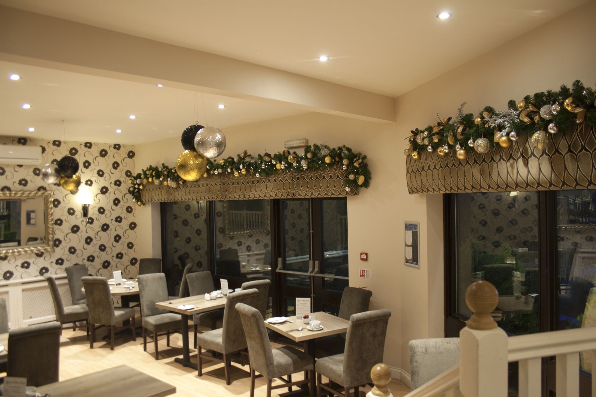 A restaurant with tables and chairs and balloons hanging from the ceiling.
