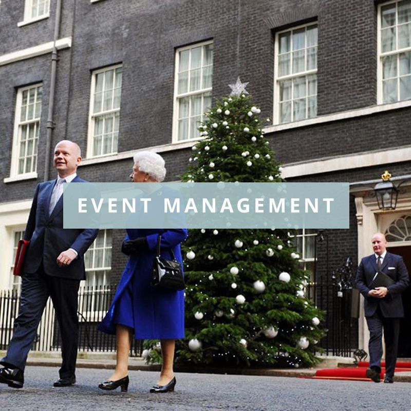 People walking in front of a christmas tree with the words event management above them.
