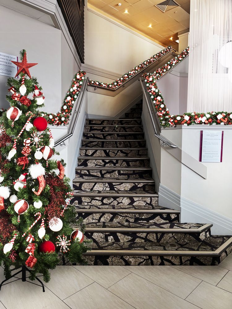 A staircase with a christmas tree in front of it