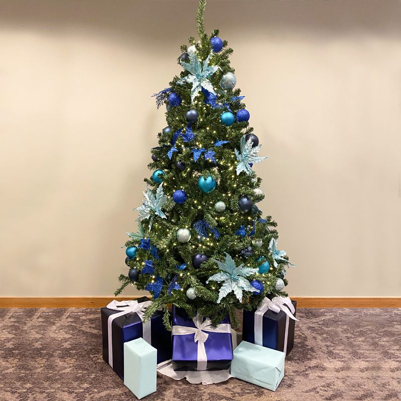 A christmas tree with blue and white decorations and gifts underneath it