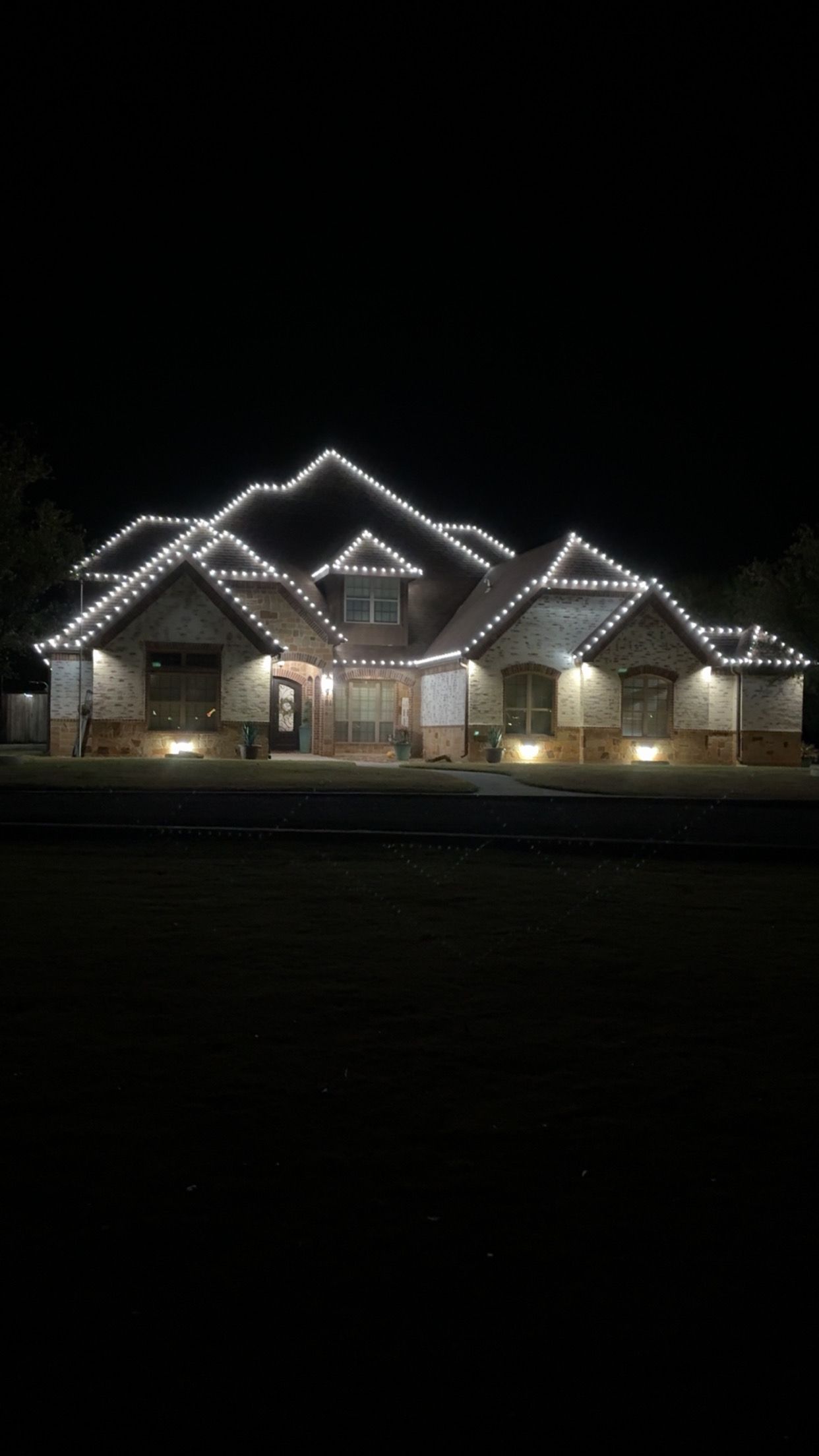 Festive house decorated with Christmas lights and wreaths.