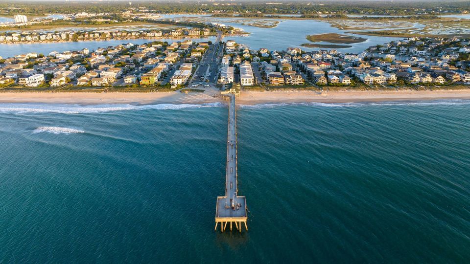 Aerial view of an ocean fishing pier and oceanfront homes on the Outer Banks