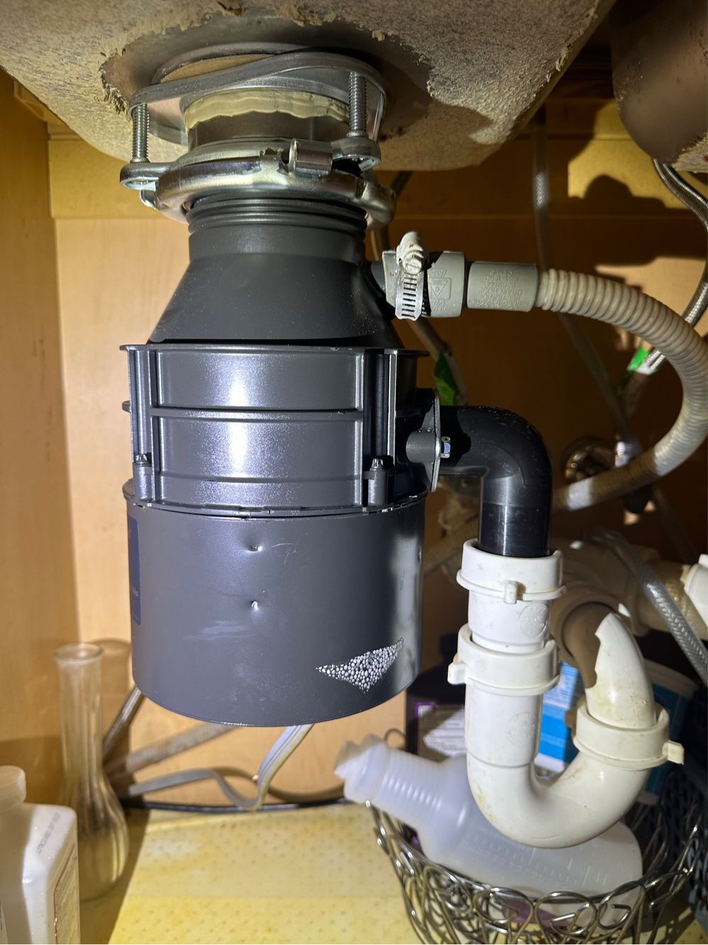 A garbage disposal is sitting under a sink in a kitchen.