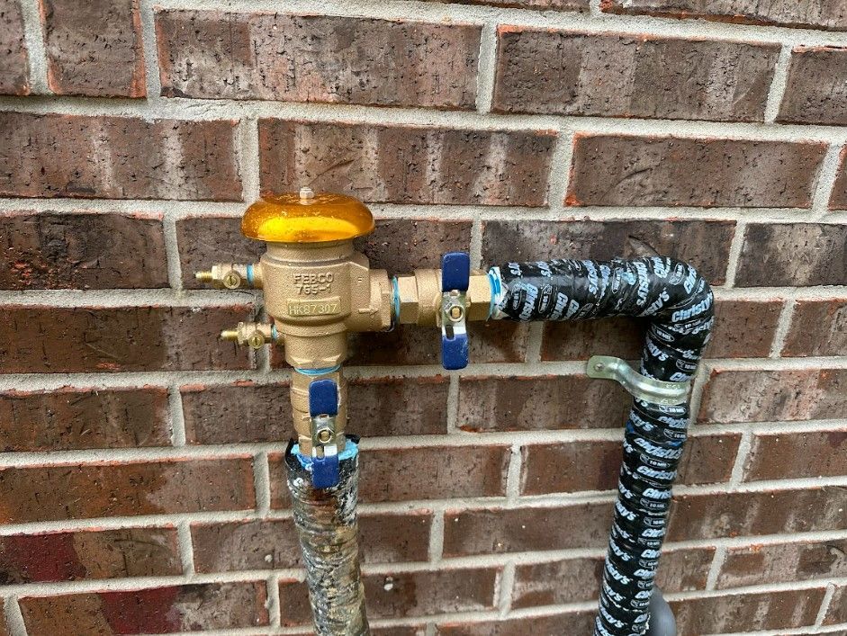 A close up of a water valve on a brick wall.