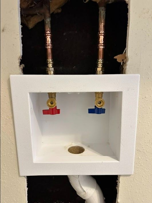 A white sink with two red and blue valves on it.