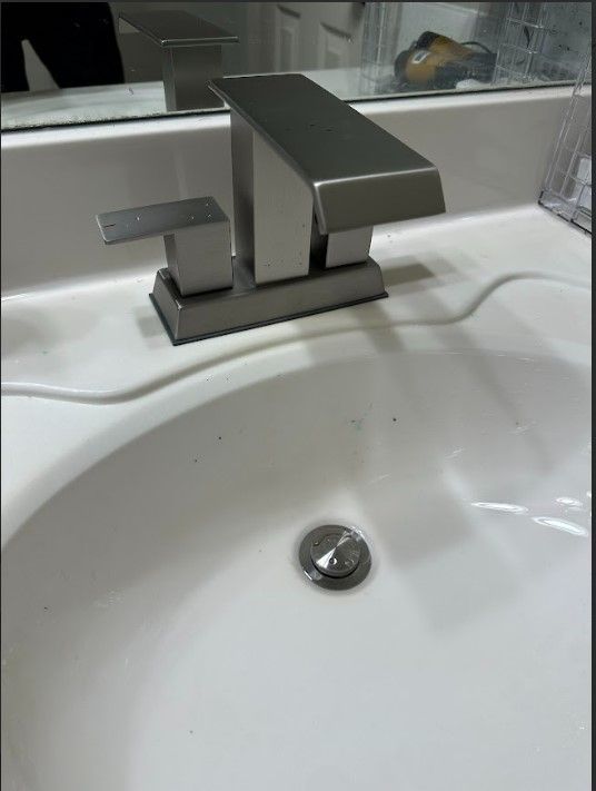 A bathroom sink with a stainless steel faucet