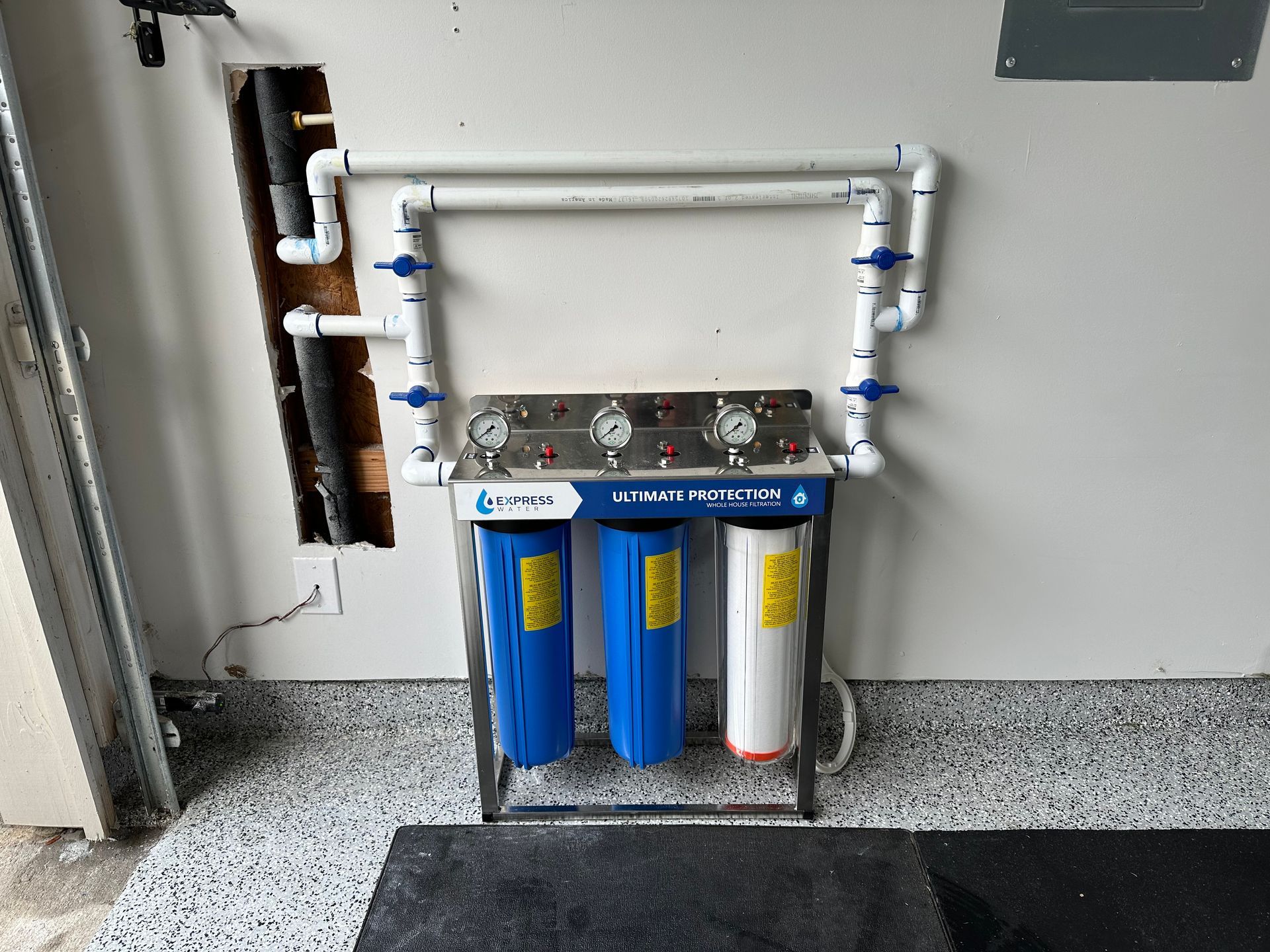 A water filter is hanging on a wall in a garage.