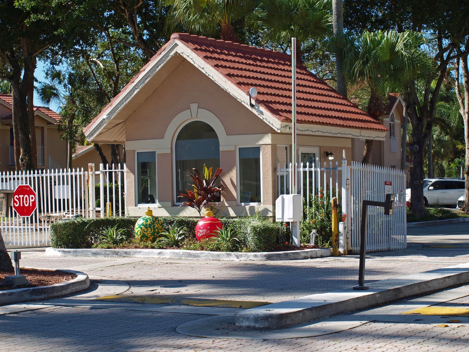 High-rise condos with red tile roofs and tan exteriors, near a river and bridge.