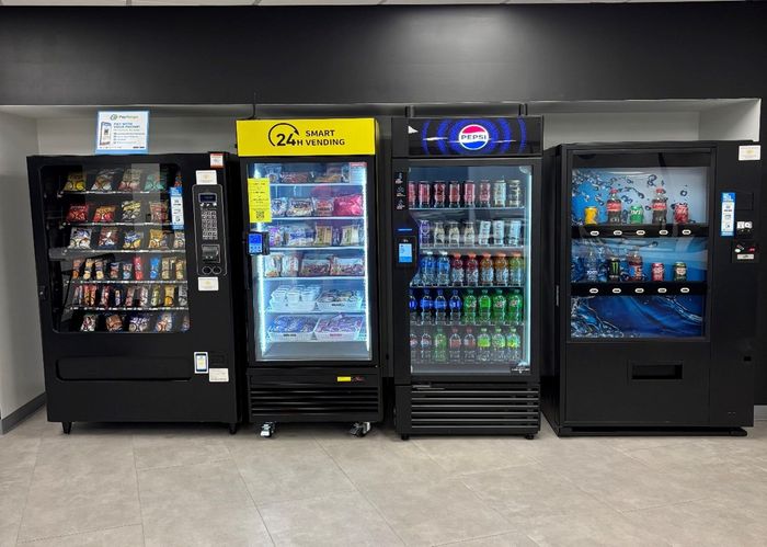 Four vending machines: snacks, a game machine, drinks, and water, lined up against a wall.