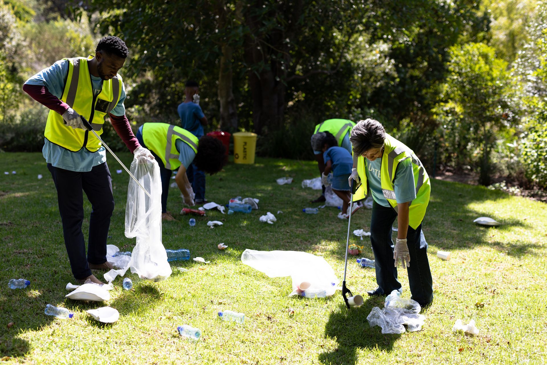 A group of people are picking up trash in a park.