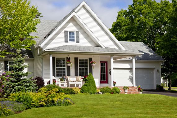 A white house with black shutters and a red door