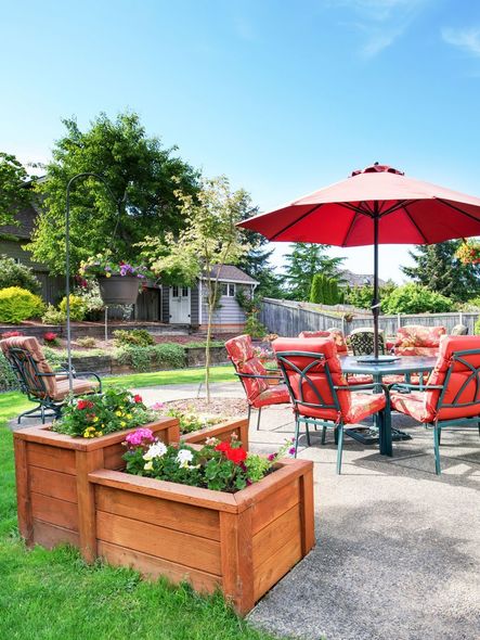 A patio with a table and chairs and a red umbrella