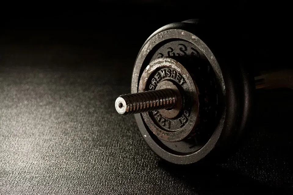 A close up of a dumbbell on a black surface.