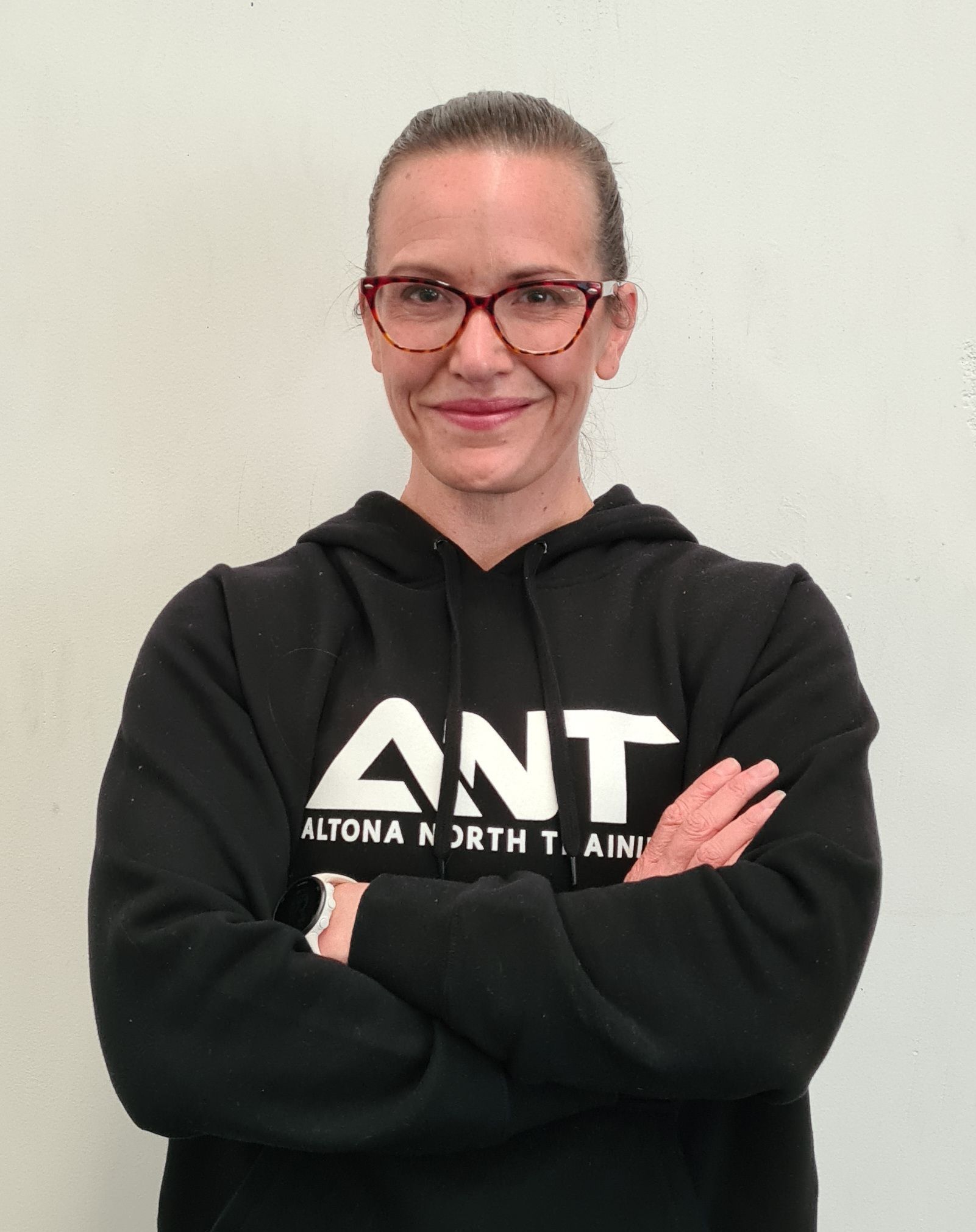 A woman wearing a black ant sweatshirt with her arms crossed