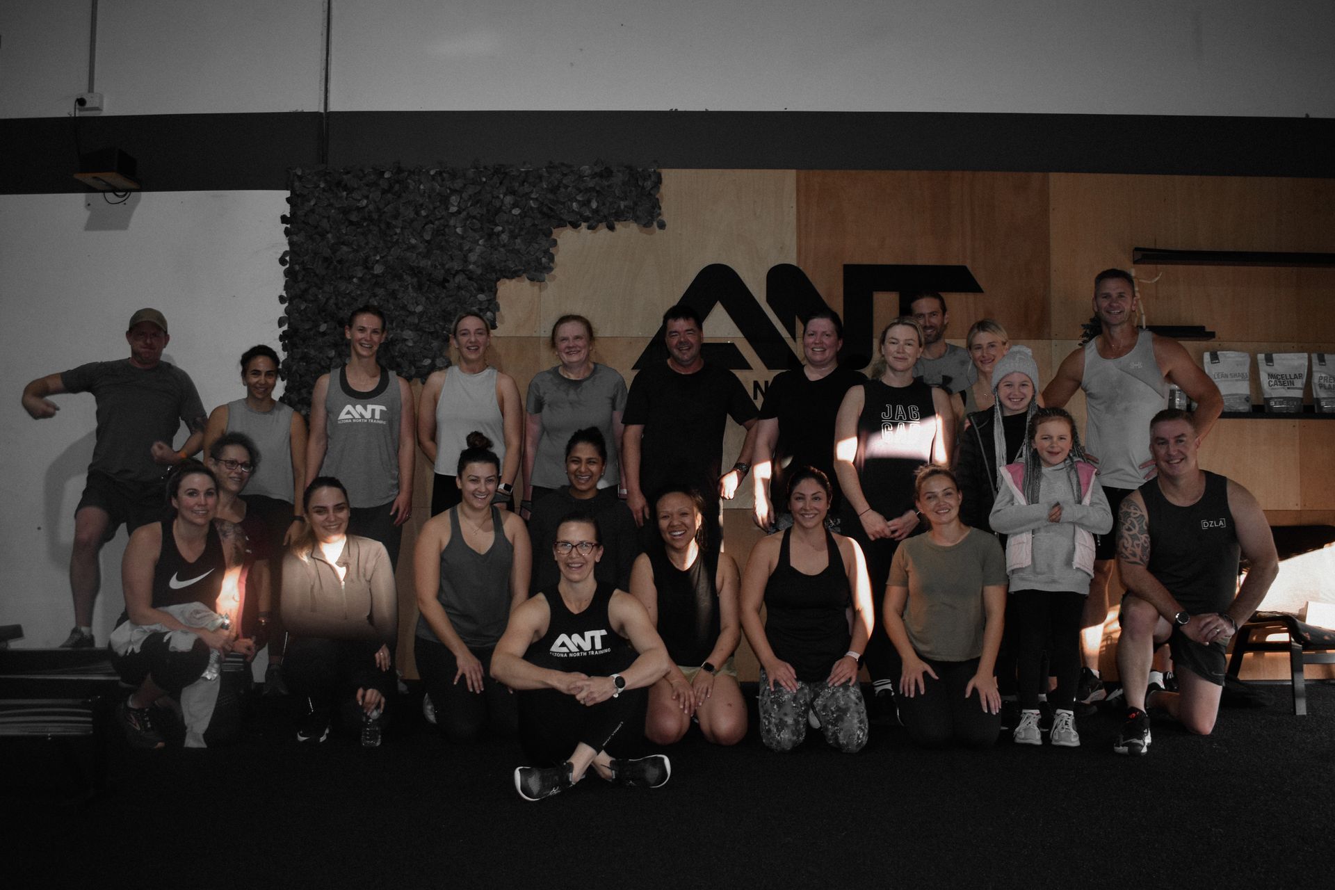 A group of people are posing for a picture in a gym.
