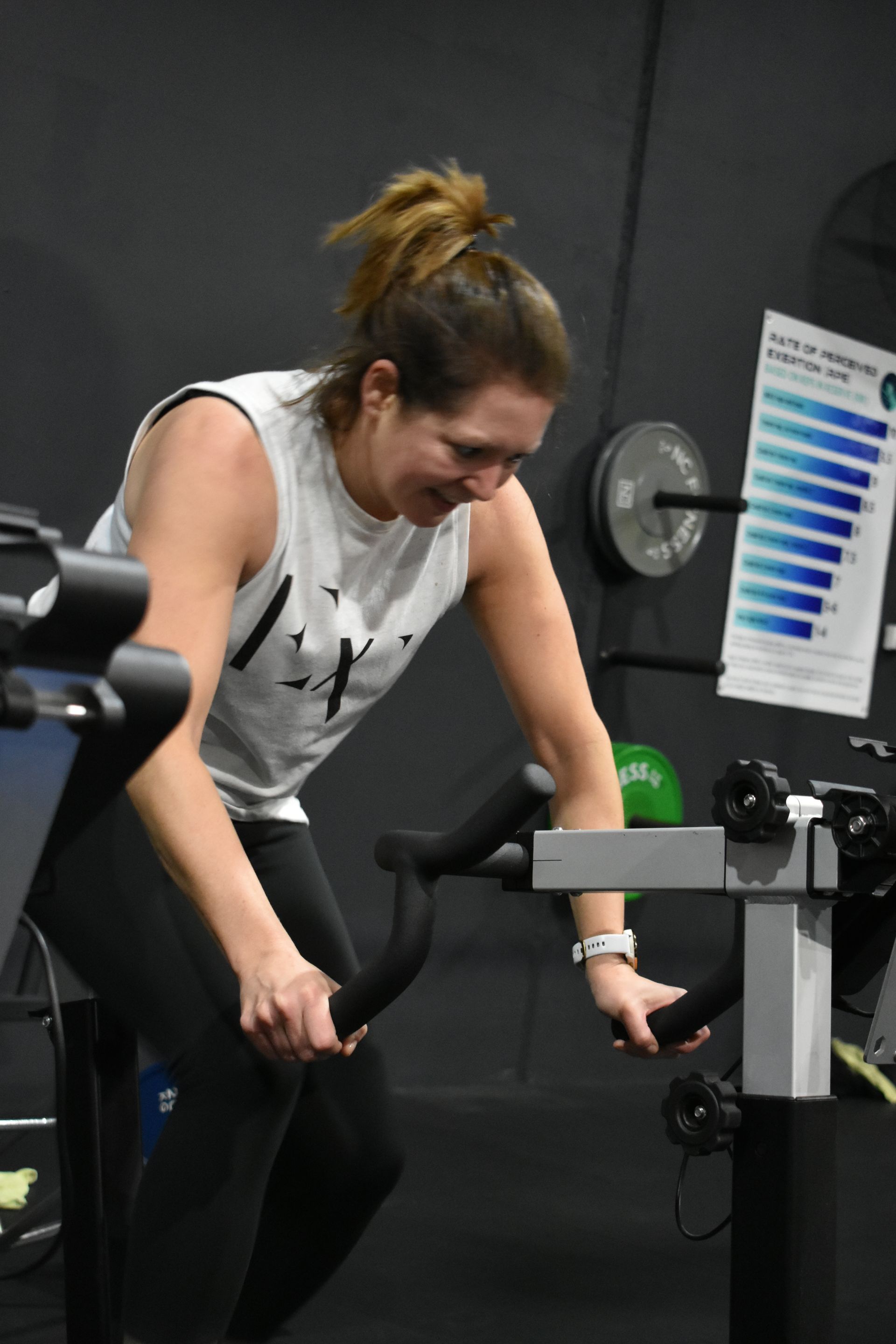A woman is riding an exercise bike in a gym.