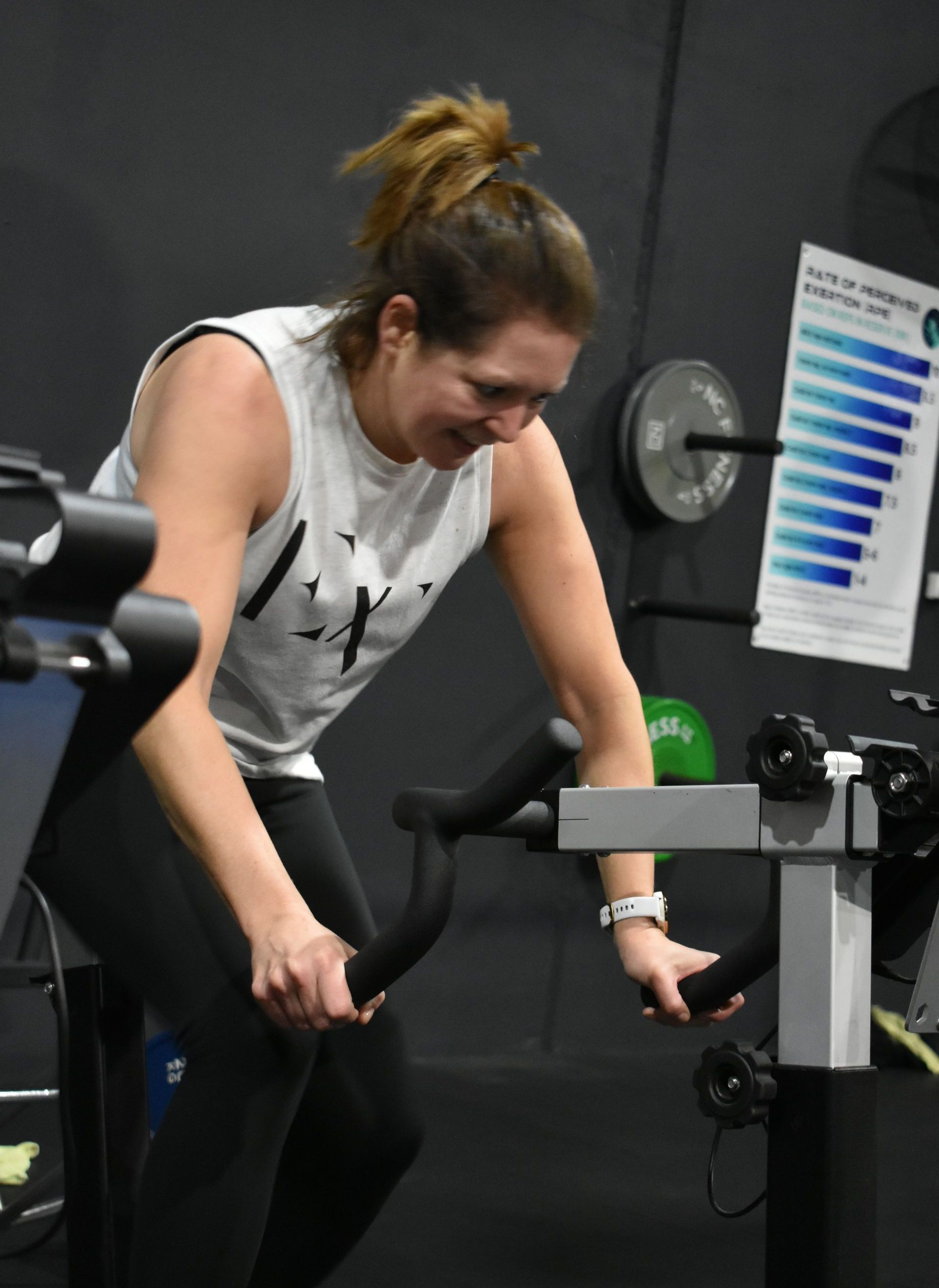 A woman is riding an exercise bike in a gym