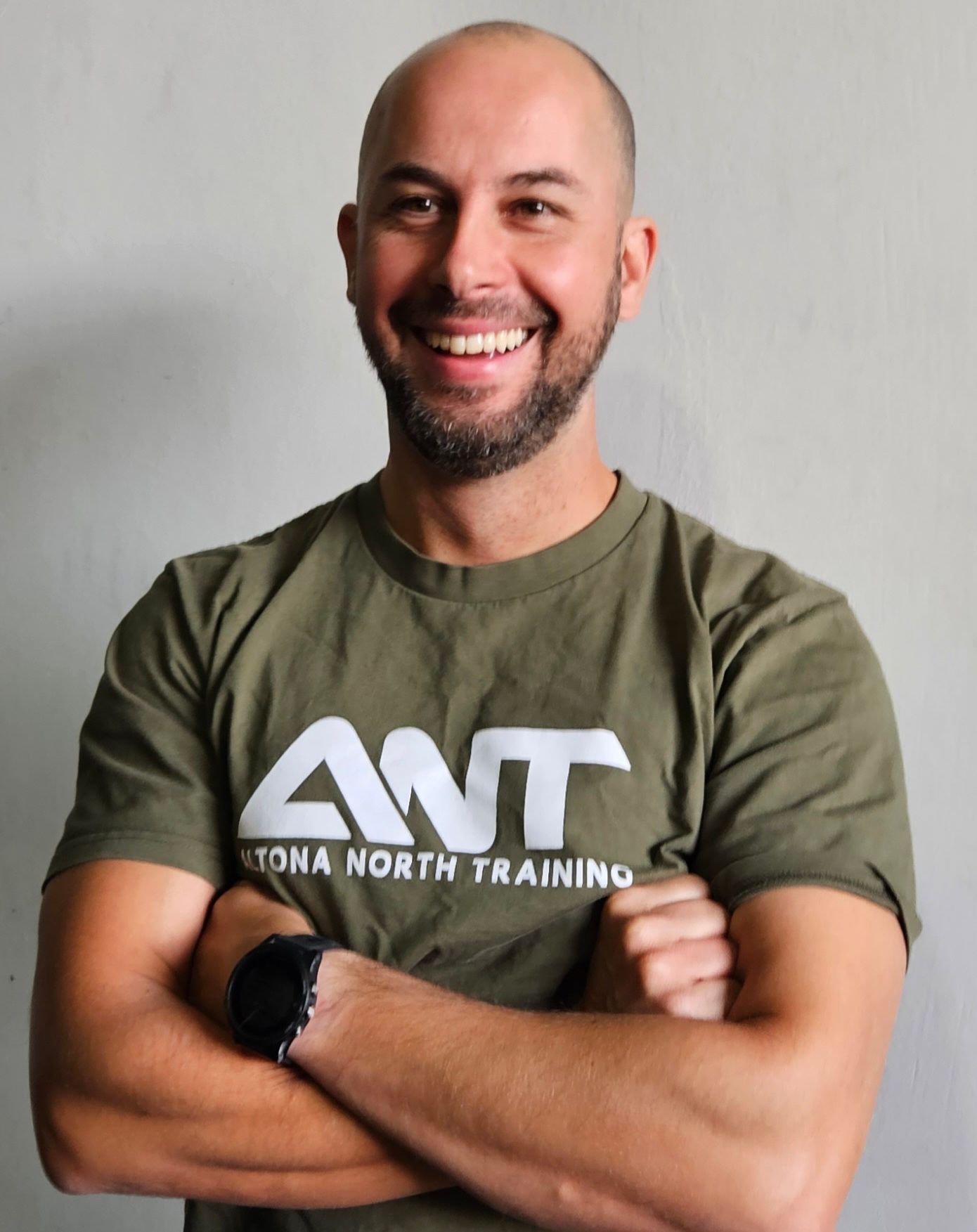 A man wearing a green shirt that says ant on it