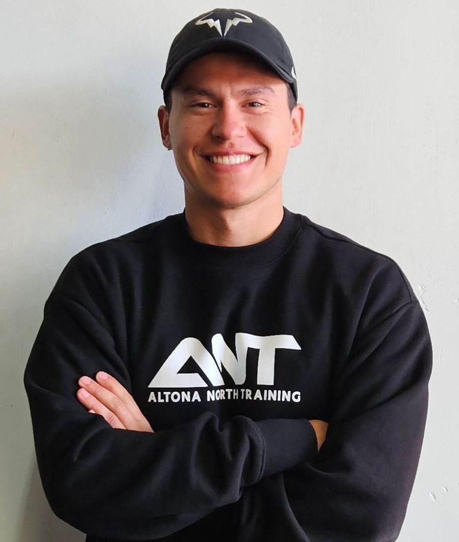 A man wearing a black shirt that says ant on it