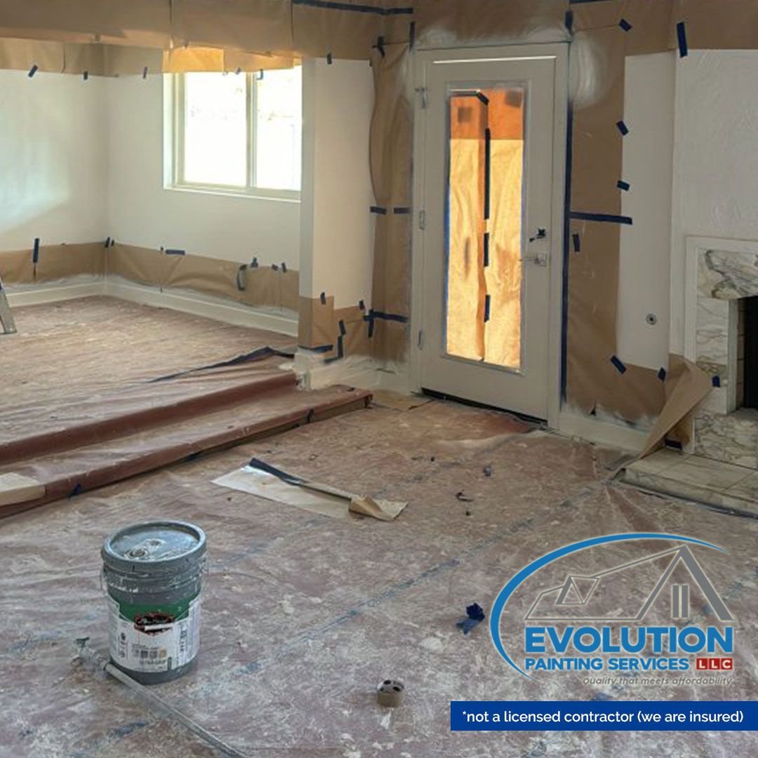 Renovated room with plastic-covered walls, exposed floorboards, window, and white door during remodeling