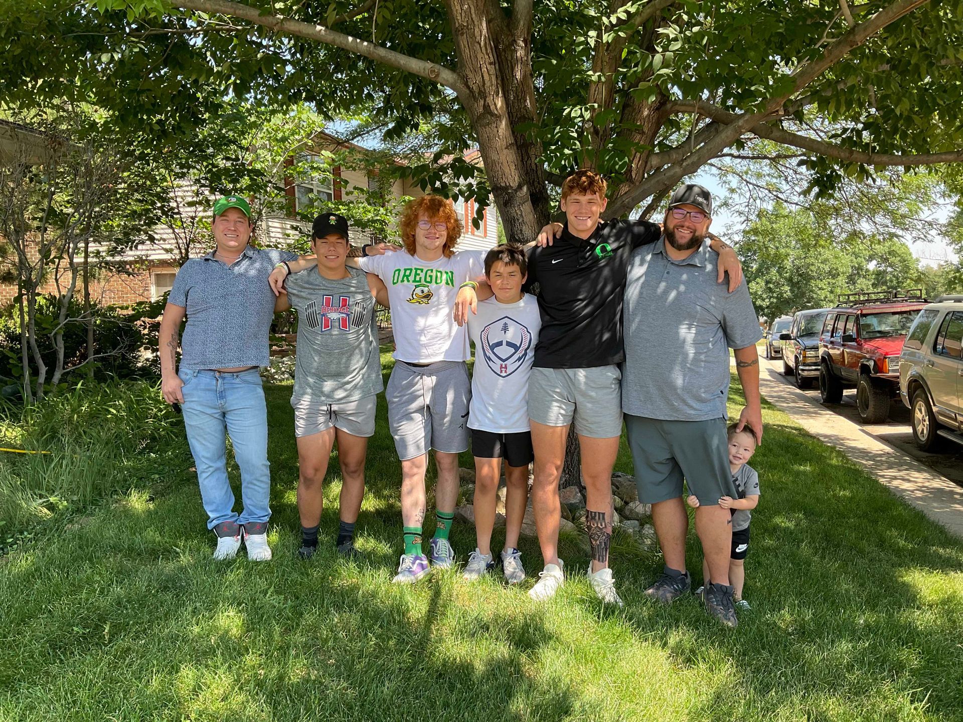 A group of people are posing for a picture in front of a tree.