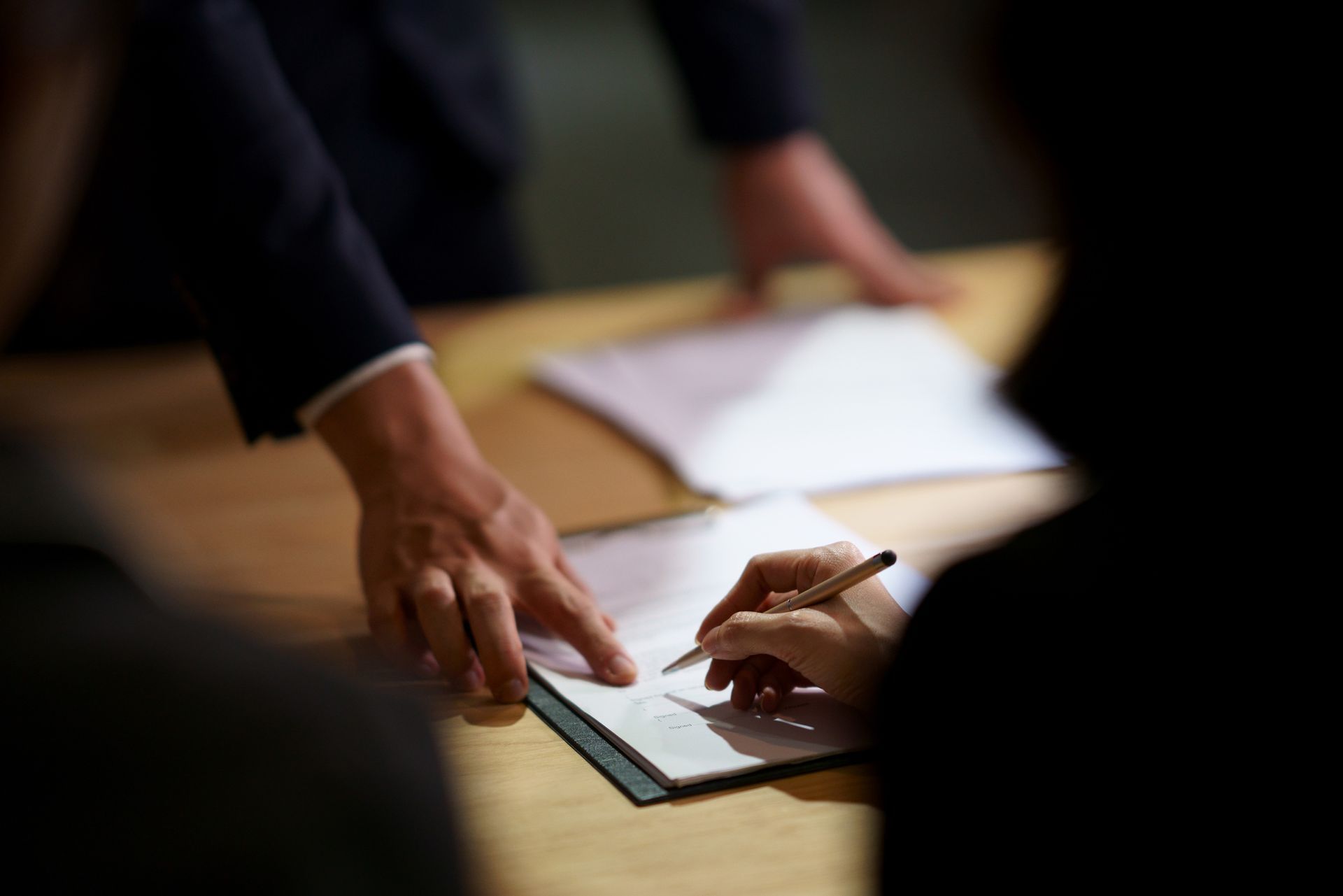 A person is writing on a piece of paper with a pen.