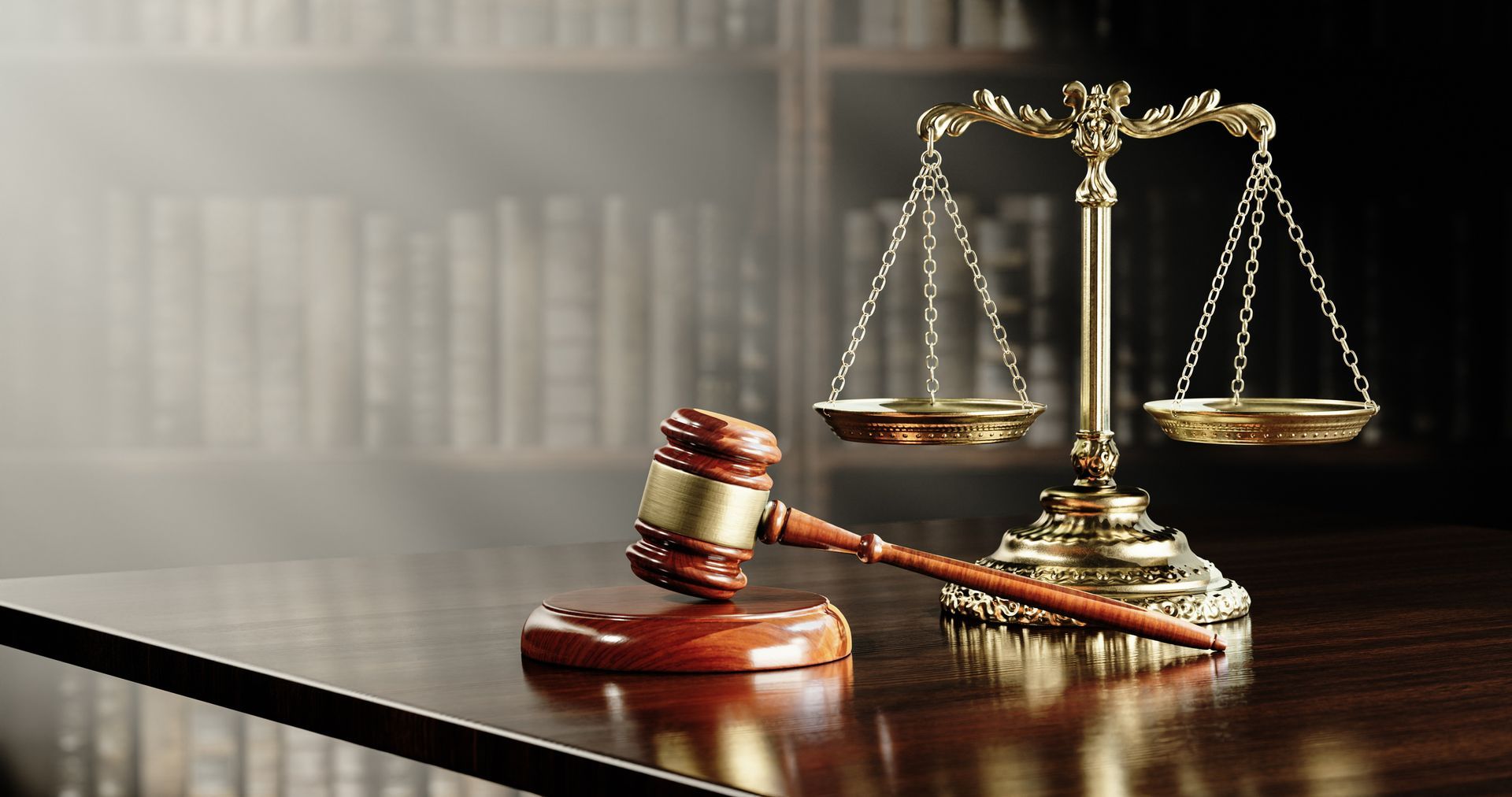 A judge 's gavel and scales of justice are on a wooden table.